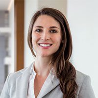 Professional woman smiling confidently in business attire.